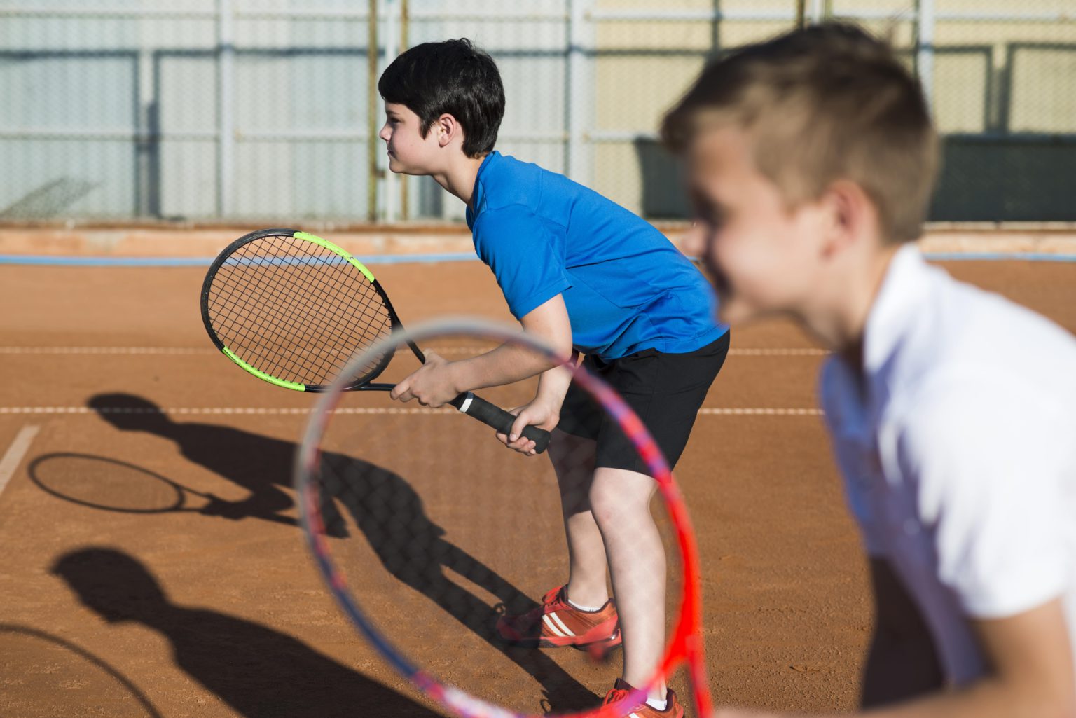 sideways-kids-playing-doubles-tennis-min-1536x1025
